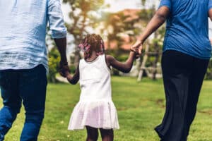 A family holding hands while running together. Representing how child therapy in Katy, TX can help families thrive together. Call us today to begin child counseling!