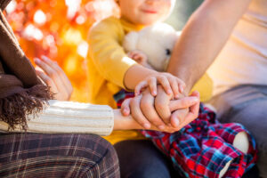 A family holding hands with their child. This represents how child anxiety counseling in Katy, TX can help strengthen family bonds. Call us today to support your child's journey. 