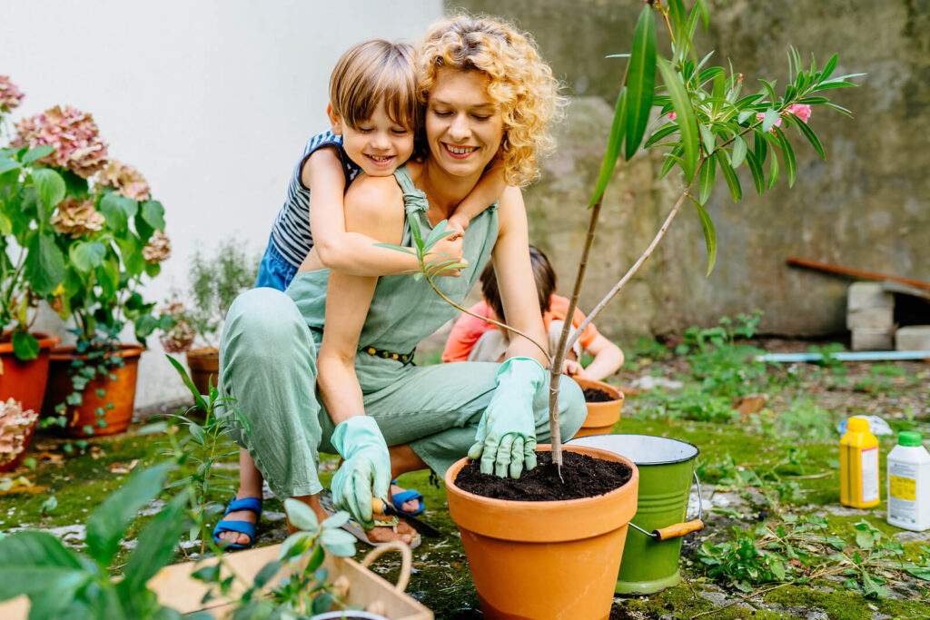 A mother & son outside while planting a tree in a pot. Our child therapy in Katy, TX can enhance parent-child relationships. Our child therapists are here to help!