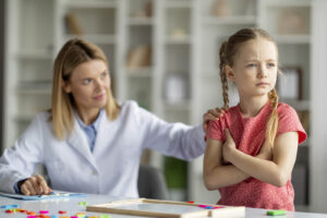 A child crossing their arms & looking away from a child therapist. Representing how children anxiety symptoms look different than adults. Learn more from a child therapist in Katy, TX.