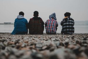 A group of teen boys sitting down near a body of water in the rocks. If you notice your teen's personality shift drastically, it might be time to reach out to a teen therapist in Katy, TX. Call us today to get started! 