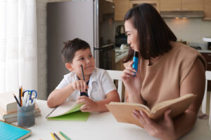 A mother & son sitting down together working on homework. If your child struggles with anxiety, call us today to begin child therapy in Katy, TX. We can help your child tackle their anxiety. 