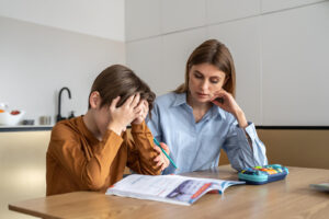 A mother & son working on homework together in the kitchen. Our child therapy in Katy, TX can help with emotional dysregulation. To learn more, read our blog here!