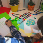 A child & therapist coloring together during therapy. A child therapist in Katy, TX can help your child with anxiety & build resilience. Watch your child thrive today!