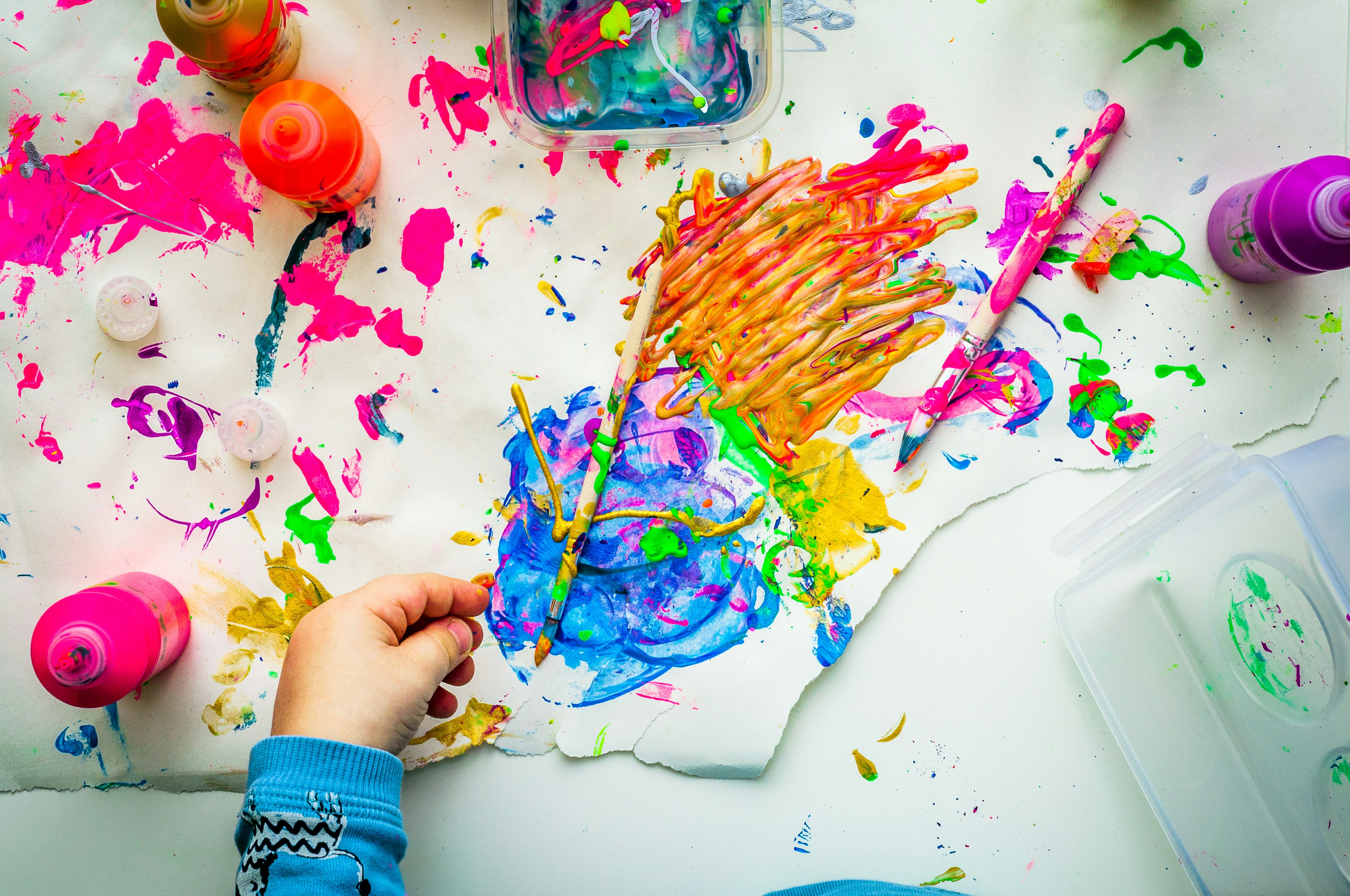 A child painting with bright blue, yellow & pink on white paper. Our child behavioral therapists in Katy, TX can help your child thrive. Reach out to get started with a child therapist.