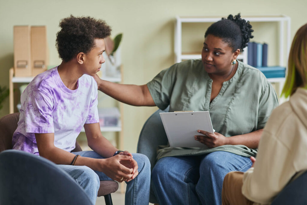 A teen therapist reaching out to a client in group therapy. This represents how our teen therapists in Katy, TX offer a safe space to explore emotions & behaviors. Reach out today to get started. 