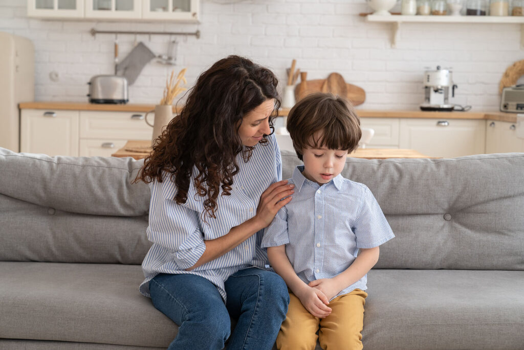 A mother sitting on a gray couch with her child who is experiencing anxiety. Our child anxiety counseling in Katy, TX can help your child & teen today. Call now to get started. 