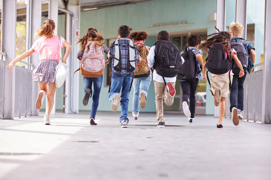 A group of diverse students running in the outside hallway toward the school doors. Child therapy in Katy, TX can help your kids create meaningful relationships. Call today to get started with a child therapist. 