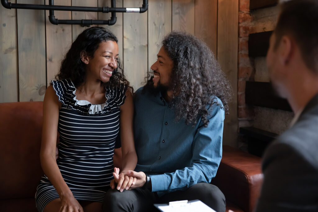 couple in therapy | counseling katy | therapy katy | therapist katy, tx | 77084 | 77433 | 77095 A biracial couple smiling at each other during a therapy session. Counseling in Katy, TX can help with anxiety, relationship struggles & more. Reach out today to get started.