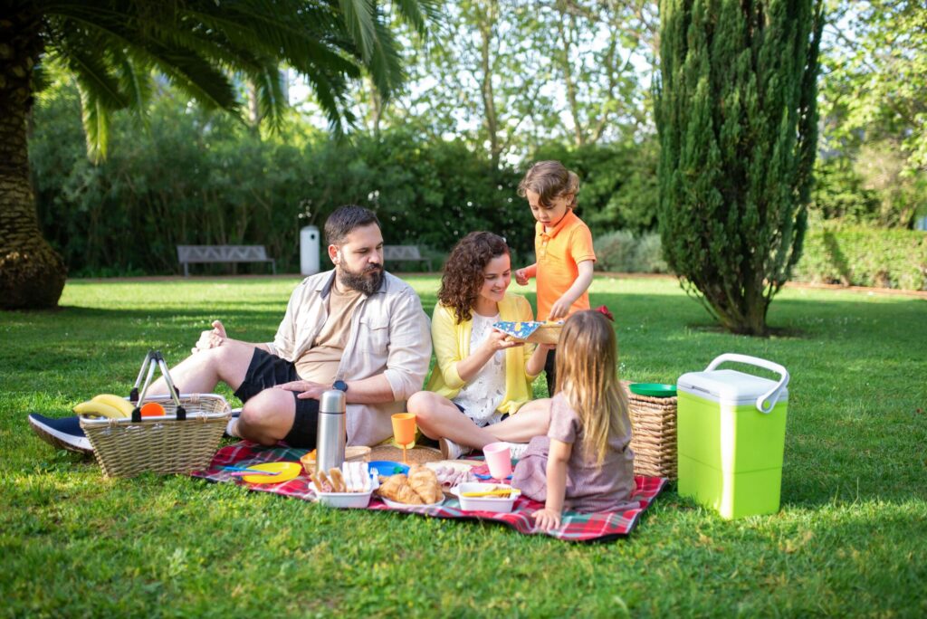 A family of four having a picnic in the park during a sunny day. Counseling in Katy, TX can help you navigate stress & anxiety with resilience. Reach out today to get started.