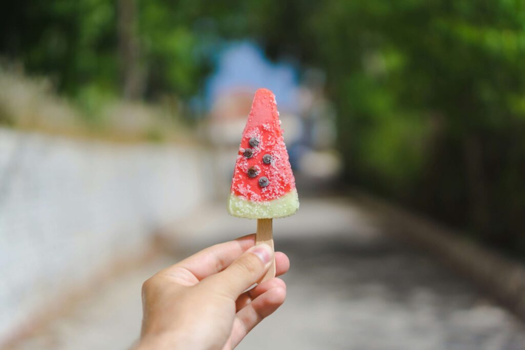 An individual holding a watermelon popsicle. Let this summer be the time of healing for your teen girl. Sign up for our teen therapy group in Katy, TX today!