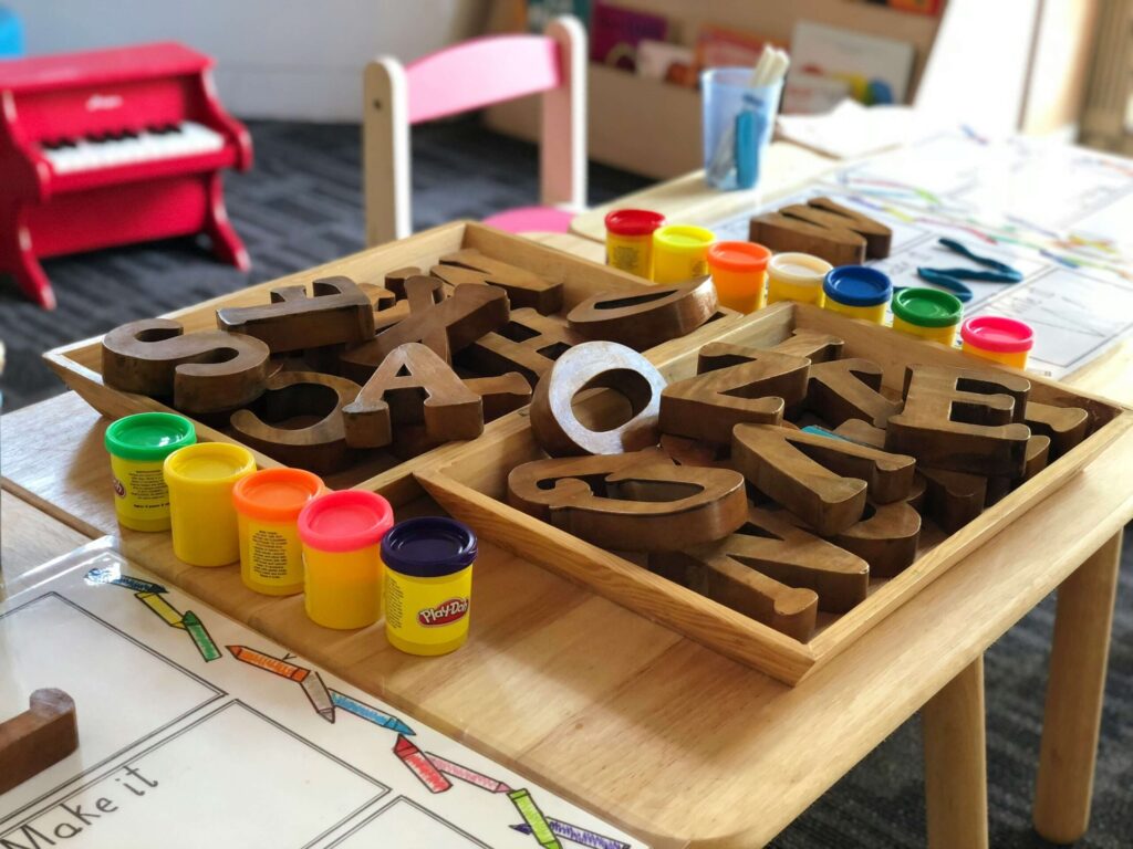 Different wooden toys on a child's table surrounded by playdough. Child therapy in Katy, TX can provide a safe space for your child to explore their feelings after trauma. Reach out today.
