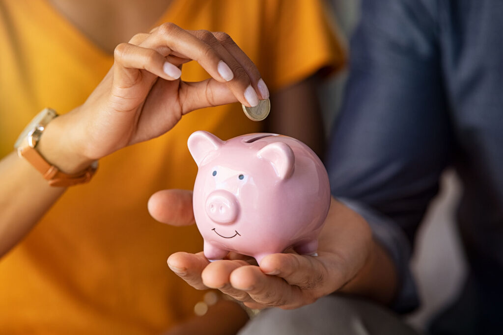 A woman with white nails putting a quarter into a pink piggy bank. WHCC offers low-cost counseling in Katy, TX to help individuals & families. Learn more here!