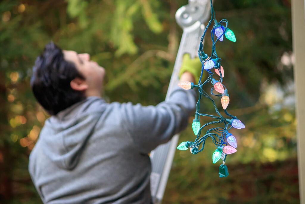 A man with dark hair holding a ladder getting ready to hang Christmas lights. If you experience burnout during the holiday season, you are not alone. Reach out today for men's therapy in Katy, TX. 
