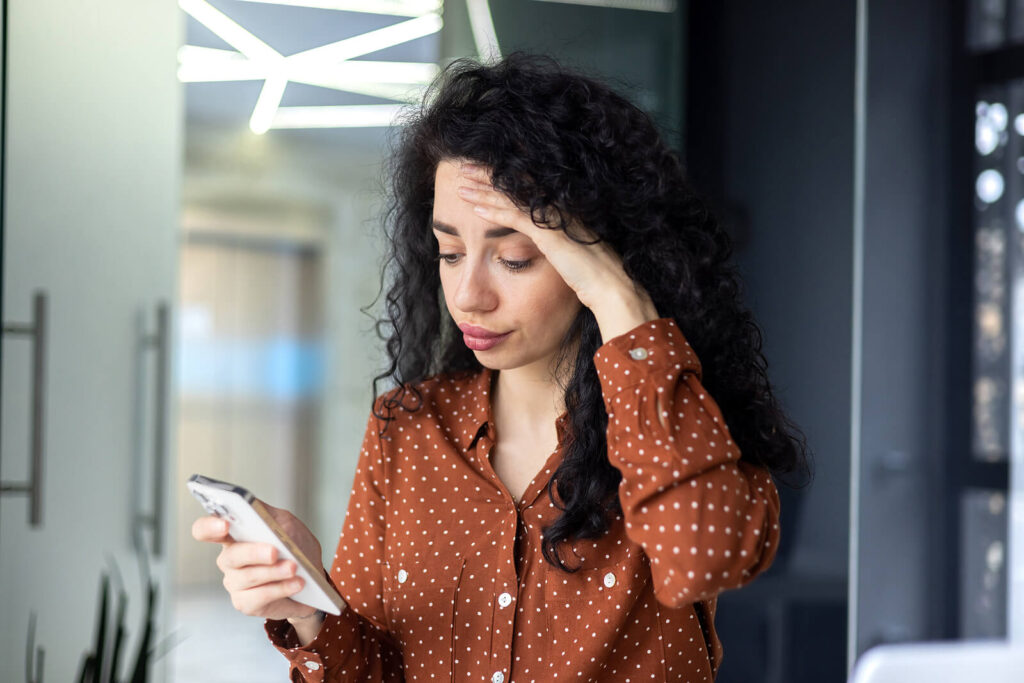 A young hispanic professional rubbing her forehead in distress as she looks at phone. Anxiety treatment in Katy, TX is different for each individual. Get paired with the right therapist today.