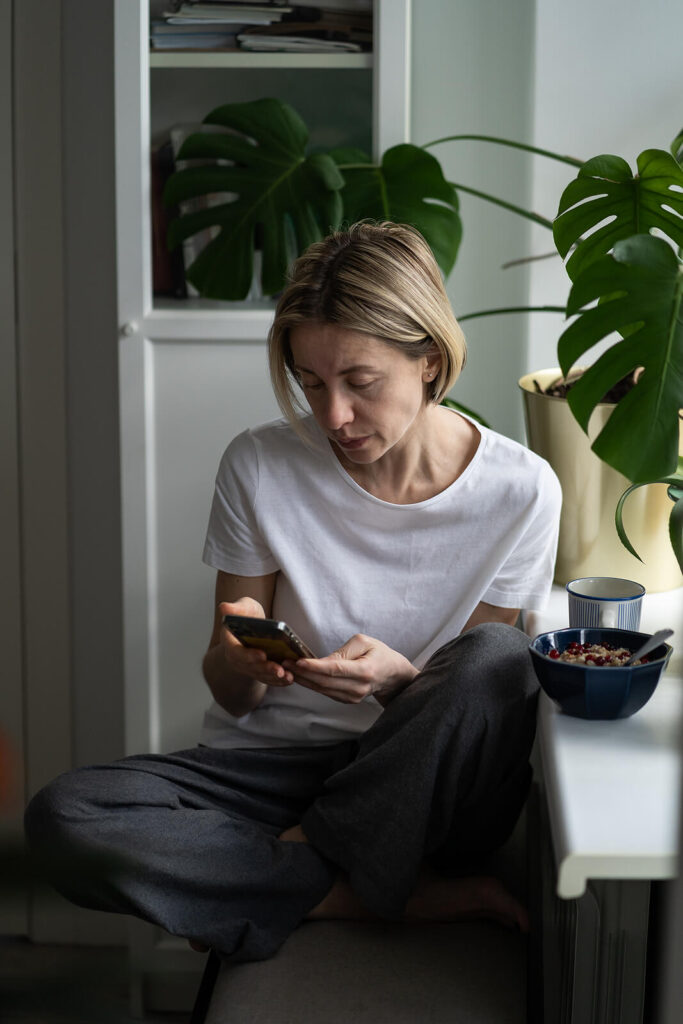 A woman sitting on a bench scrolling her phone with a curious look. Your attachment style can affect relationships, friendships & more. Discover how adult therapy in Katy, TX can help you navigate the challenges it brings. 